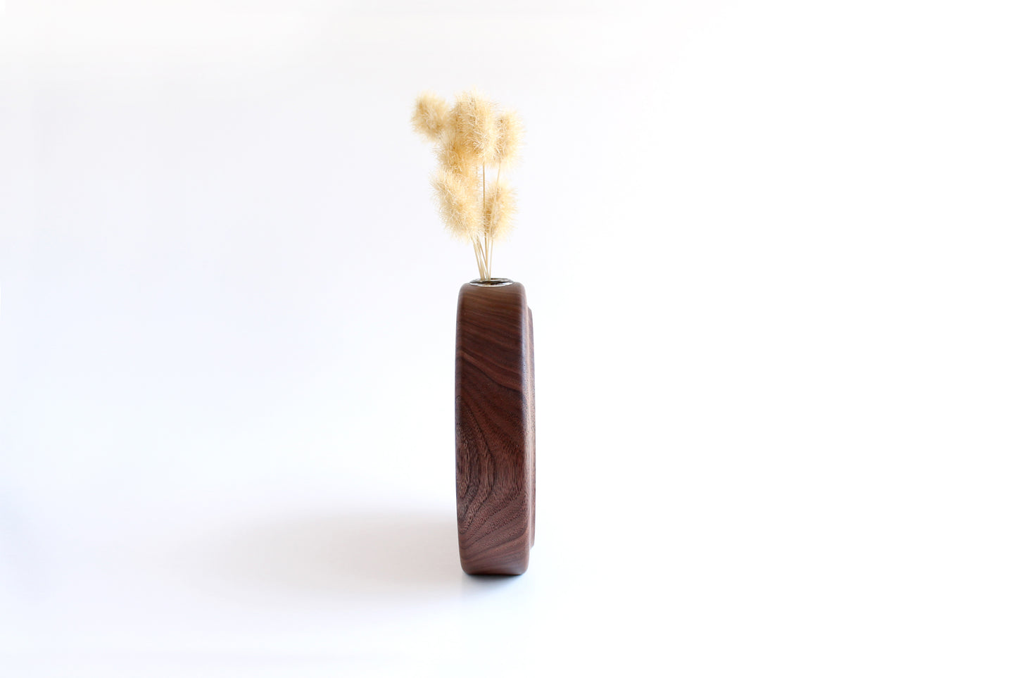 Walnut Circle Vase with Test tube for wet or dry flowers. Dried flowers shown in vase. Shown from side.