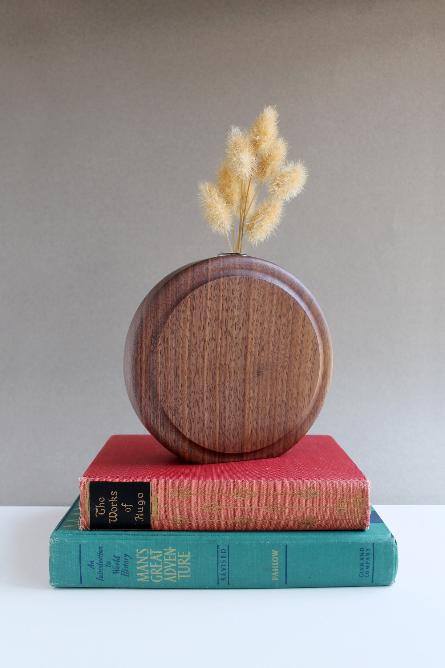 Walnut Circle Vase with test tube for wet or dry flowers. Dried flowers shown in vase and stacked on top of two books.