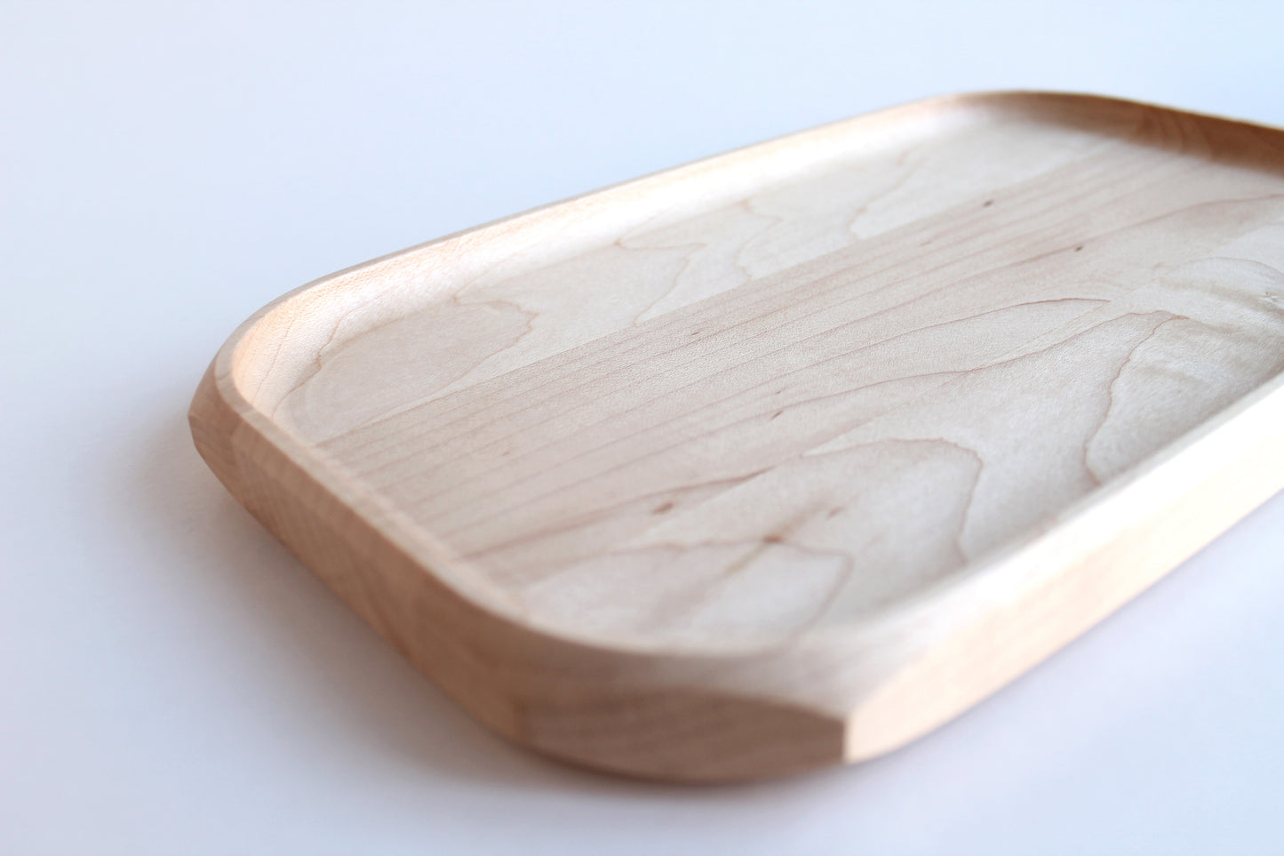 Genesis Tray in Maple wood on white background. Detail view of inside curved finger scoop radius.