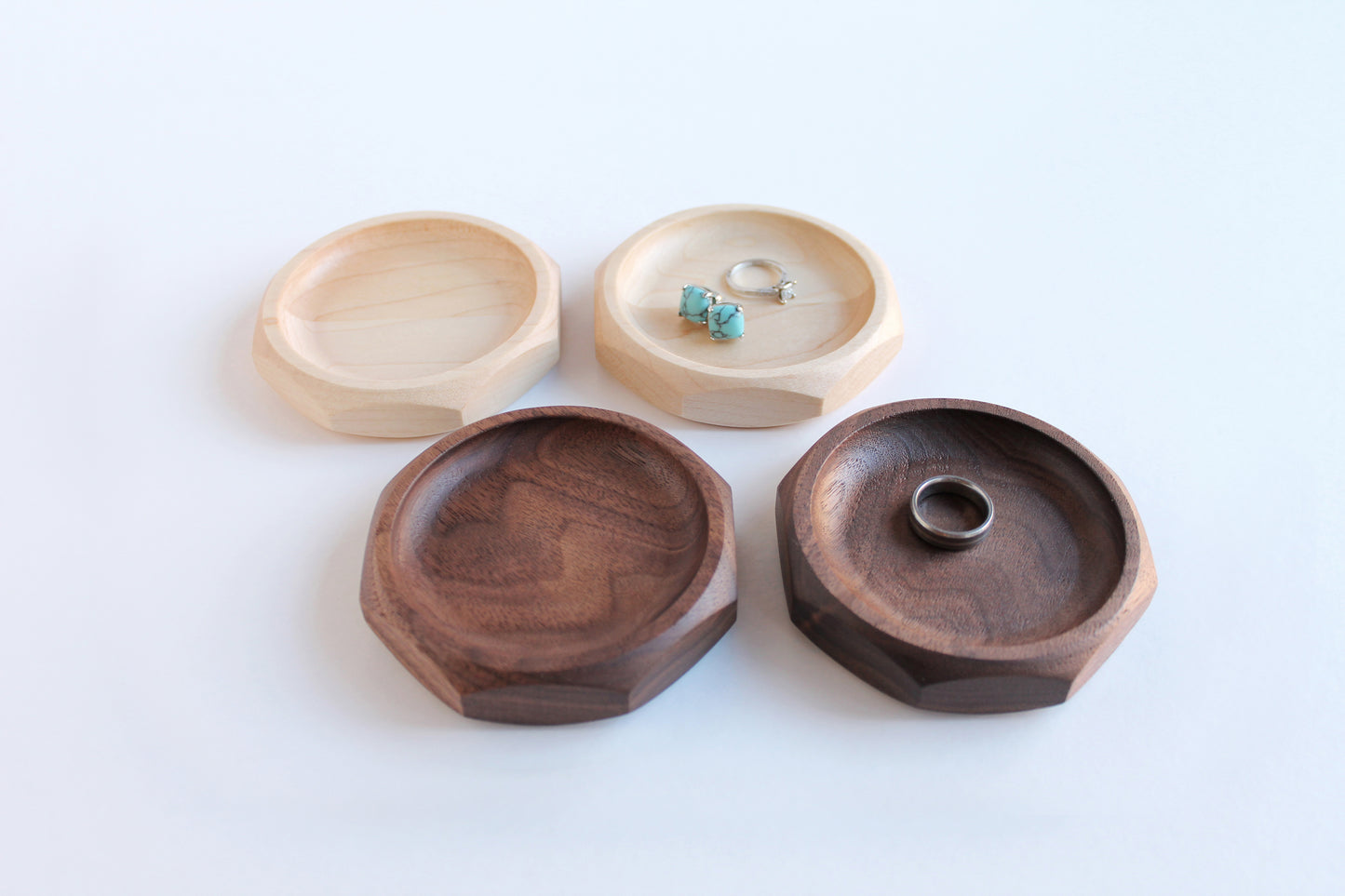 Genesis Dish top view of two maple and two walnut dishes with rings and earrings in them.