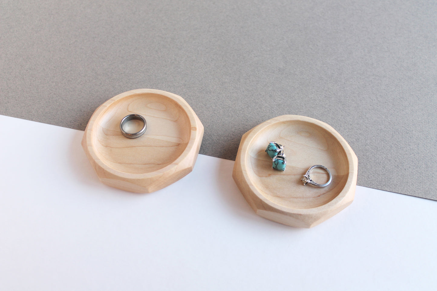Two Genesis Dishes in maple on gray and white angled background with rings and earrings in them. Alternate view