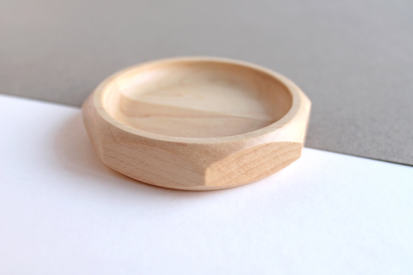 Genesis Dish in maple on gray and white angled background.