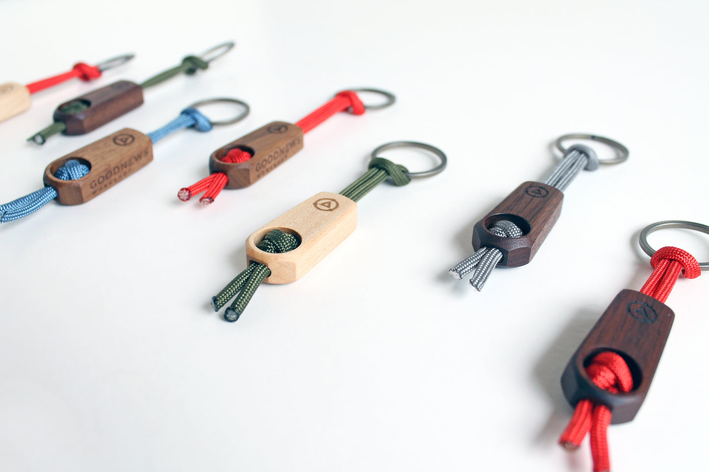 Core Key Fob with Titanium Key Ring, Paracord Lanyard and Maple Fob. Key Fobs shown in maple or walnut wood with Red, Silver, Olive and Steel Blue lanyards.