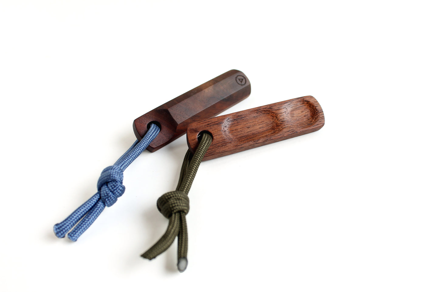 Two Thumbhill's shown in walnut with one facing up and other showing bottom. Lanyards are olive and steel blue lanyard.