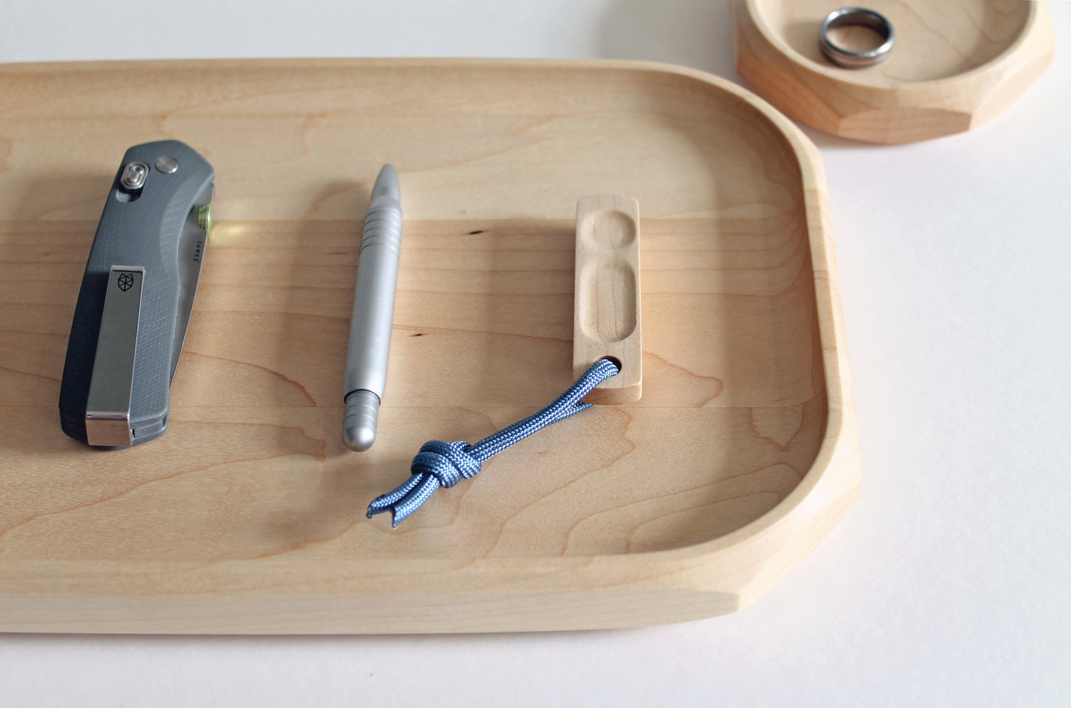 Thumbhill in Maple with steel blue lanyard shown on Maple Genesis Tray with pen and pocket knife.
